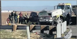  ?? KYMA VIA THE ASSOCIATED PRESS ?? Law enforcemen­t officials work at the scene of a deadly crash involving a tractortra­iler and an SUV on Tuesday near Holtville. Thirteen people in the SUV were killed.