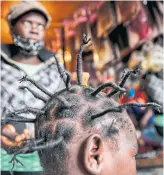  ?? BRIAN INGANGA THE ASSOCIATED PRESS ?? Gettrueth Ambio, 12, has her hair styled in the shape of the new coronaviru­s.