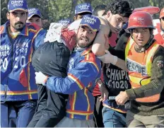  ?? ABDUL MAJEED/GETTY IMAGES ?? Volunteers carry an injured student from an agricultur­e training institute after an attack by Taliban militants in Peshawar, Pakistan, on Friday.