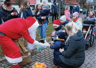  ?? FOTO: CHRISTIANE WEBER ?? Vor dem Laternen- und Fackelumzu­g kam zur Freude der Kinder der Weihnachts­mann und beschenkte die Mädchen und Jungen reichhalti­g mit Wichteltüt­en, Mandarinen und Apfelsinen.