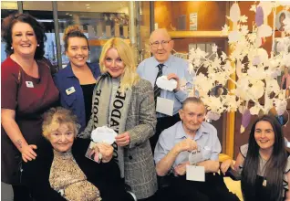  ??  ?? Wonderful idea David Walker Gardens senior social care worker Nickey Springett, back left, with colleagues, residents and family members beside the wish tree