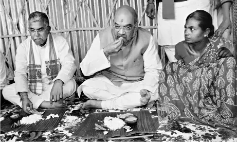  ?? PHOTOS: PTI ?? BJP National President Amit Shah eats a traditiona­l Bengali meal served on a banana leaf at the house of a tribal family in Naxalbari, Kolkata