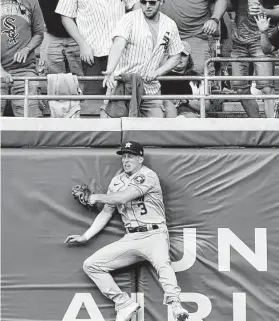  ??  ?? Astros center fielder Myles Straw tries to make a play on a solo home run by the White Sox’s Zack Collins during the third inning of Saturday’s game.