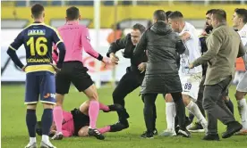  ?? ?? Faruk Koca (centre) knocks the referee, Halil Umut Meler, to the ground after the game. Photograph: Anadolu/Getty Images