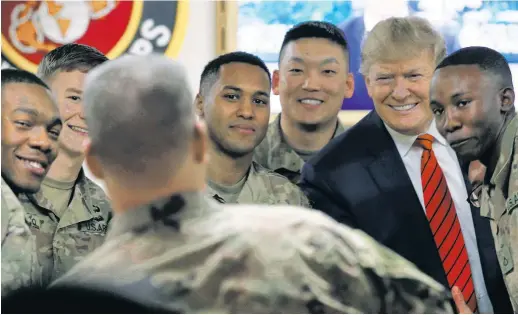  ??  ?? COMMANDER-IN-‘CHEESE’ . . . as in “say cheese!” Soldiers flash their broadest smiles as they get in face time with President Trump at Bagram Air Base Thursday. Their commander praised the troops in an address (opposite page), saying, “We thank God for your help and all the things that you’ve done.”