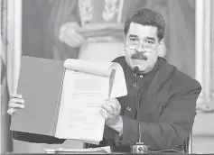  ??  ?? Maduro holds a document as he speaks during a ceremony at Miraflores Palace in Caracas, Venezuela. — Reuters photo