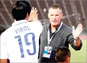  ?? SRENG MENG SRUN ?? Boeung Ket coach John McGlynn congratula­tes defender Khiev Vibol after the 1-1 draw with Lao Toyota in AFC Cup qualifying at Olympic Stadium on January 31.