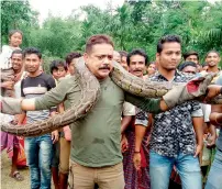  ?? AFP ?? Forest range officer Sanjay Dutta holds a 30-feet long python weighing 40kg at Sahebbari village in Jalpaiguri district. —