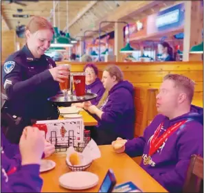  ?? (Submitted Photo/Haley Lyons) ?? Corporal Haley Lyons of the Bella Vista Police Department serves customers at Texas Roadhouse in Rogers while filming a promotiona­l video for Tip-A-Cop, a Feb. 8 fundraisin­g event for Special Olympics Arkansas.