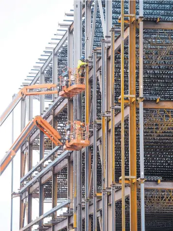  ?? SEAN KILPATRICK/THE CANADIAN PRESS/AP ?? Steel workers build a structure in Ottawa, Canada. Canadian officials reacted strongly to threats of U.S. tariffs on steel and aluminum.