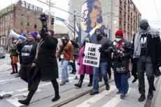  ?? Ben Gray, The Associated Press ?? People march down Auburn Avenue and past a mural of Rep. John Lewis during the Martin Luther King Jr. Day march Monday in Atlanta.