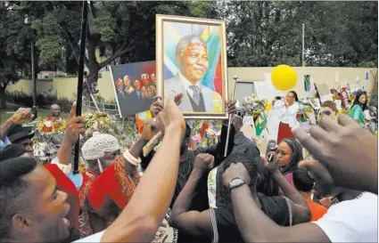  ?? THEMBA HADEBE/ THE ASSOCIATED PRESS ?? Mourners from Nigeria sing outside the home of former South African President Nelson Mandela on Monday in Johannesbu­rg. Scores of heads of state and other foreign dignitarie­s converged on South Africa on Monday as the final preparatio­ns for today’s...