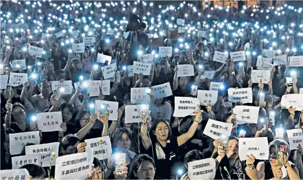  ??  ?? Mothers holding placards, some of which read ‘If we lose the young generation, what’s left of Hong Kong’, during a vigil in support of their children on Friday evening