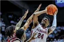  ?? AP PHOTO/VASHA HUNT ?? Alabama forward Brandon Miller (24) shoots over Arkansas guards Nick Smith Jr., left, and Davonte Davis during an SEC regular-season game on Feb. 25 in Tuscaloosa, Ala.