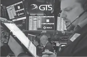  ?? BRYAN R. SMITH/AFP VIA GETTY IMAGES ?? Trading is halted for 15 minutes as traders work on the floor at the opening bell at the New York Stock Exchange on Thursday.