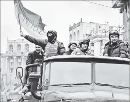  ??  ?? This is not a drill: Anti-government protesters, one holding the Ukrainian national flag, during the uprising in Kiev in February 2014.