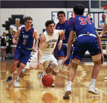  ?? RANDY MEYERS — THE MORNING JOURNAL ?? Vermilion’s Joby Pfeil brings the ball up court and splits three Bay defenders during the first quarter.