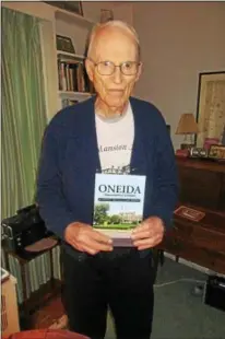  ??  ?? Author John P. L. Hatcher holds his new book “Oneida (Community) Limited: A Goodly Heritage Gone Wrong” at his Kenwood home on May 24. The story is an historical account of the rise and fall of the Oneida Ltd. company, where he was a longtime employee...