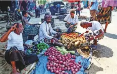  ?? AFP ?? A shopper buys produce at a street market in the Red Sea port city of Hodeida on Friday.