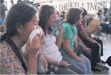  ?? PHOTOS BY AFP ?? Relatives of victims of extra-judicial killings in former president Rodrigo Duterte’s drug war cry as they listen to stories by other relatives during a gathering at a church in Manila on April 8.