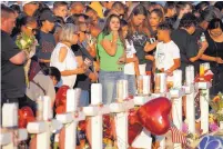  ?? JOHN LOCHER/ASSOCIATED PRESS ?? Last week, people visit a makeshift memorial at the scene of the mass shooting that killed 22 people and wounded nearly two dozen at a Walmart in El Paso.