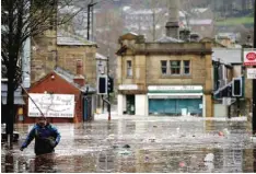  ??  ?? WEST YORKSHIRE: A man wades through flood waters at Hebden Bridge in West Yorkshire, England yesterday. — AP