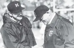  ?? ASSOCIATED PRESS FILE PHOTO ?? Michigan coach Bo Schembechl­er, left, meets with Ohio State coach Woody Hayes at game during the 1970s. The two coaches were kindred spirits as they clashed in what became known as the 10-Year War between Ohio State and Michigan. The mutual respect that has been a pillar of what is arguably college football’s greatest rivalry appears to be lacking these days — even among the coaches.