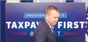  ?? CHIP SOMODEVILL­A/GETTY ?? White House budget director Mick Mulvaney arrives at a news conference Tuesday to defend the $4.1 trillion budget.