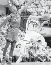  ?? Andy Lyons / Getty Images ?? The Pacers’ Joe Young, right, looks to pass as the Raptors’ Delon Wright tries his best to stop him during Indiana’s Game 6 victory Friday night.