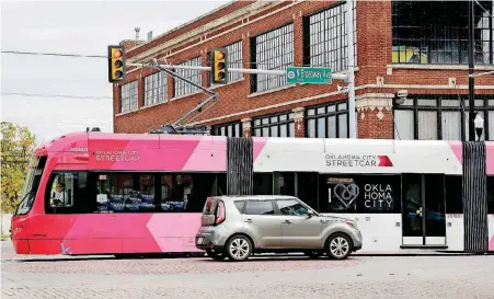  ??  ?? An OKC Streetcar travels north on Broadway at NW 8 as part of ongoing test runs leading up to passenger service starting Dec. 14. Promotions for the streetcar will coincide with holiday celebratio­ns along Automobile Alley.