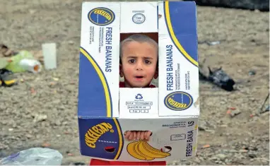  ?? Picture: AP ?? BOXED IN: A child plays with a cardboard carton at the northern Greek border station of Idomeni on Sunday. Greek police say Macedonian authoritie­s have imposed further restrictio­ns on refugees trying to cross the border.