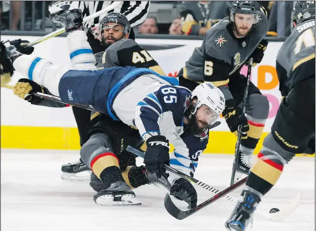  ??  ?? Jets centre Mathieu Perreault trips over the Golden Knights’ Pierre-Edouard Bellemare during Game 3 of the Western Conference final last night. JOHN LOCHER/AP