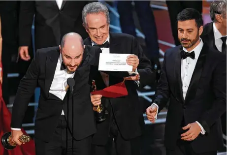  ?? Chris Pizzello / Invision / AP ?? Jordan Horowitz, producer of “La La Land,” shows the envelope revealing “Moonlight” as the true winner of best picture at the Oscars on Sunday after presenter Warren Beatty, center, and host Jimmy Kimmel helped confirm the initial flub.