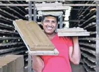  ??  ?? Die 45-jährige Diandra arbeitet in Antons Tile Factory und schleppt dort handgearbe­itete Dachziegel.