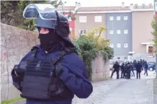  ?? THE ASSOCIATED PRESS ?? Police officers cordon off the area at a shooting suspect’s residence in Carcassonn­e, southern France, on Friday.