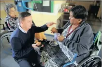  ??  ?? Shoprite Checkers chief operating officer Willem Hunlum hands out a muffin
to 78-year-old Maralyn Oday, a resident at The Natal Settlers Memorial Homes in Umbilo, Durban, during
Mandela Day activities yesterday. Shoprite staff had also spruced up the...