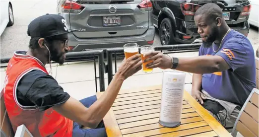  ?? BRIAN RICH/SUN-TIMES ?? Sam Ross (left) and Jay Westbrook enjoy a Harold’s ’83 Honey Ale at Haymarket Brewing.