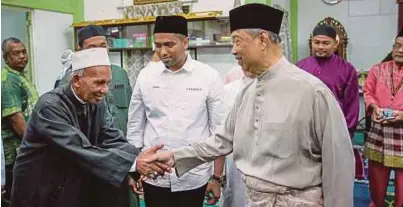  ?? [FOTO ASYRAF HAMZAH/BH] ?? Muhyiddin bersalam dengan jemaah selepas solat Jumaat di Masjid Kampung Batu 3, sempena kempen PRK DUN Semenyih, semalam, sambil diiringi calon PH, Muhammad Aiman Zainali.