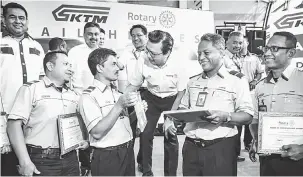  ?? — Gambar Bernama ?? RAMAH MESRA: Liow Tiong Lai (tengah) beramah mesra bersama pekerja Keretapi Tanah Melayu Berhad yang menerima ‘Pride of Workmanshi­p Award’ di KL Sentral semalam.