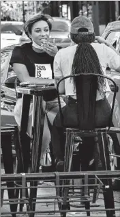  ?? ZBIGNIEW BZDAK/CHICAGO TRIBUNE ?? Emmanuella Carter, left, and Jasmine Sims dine outside Thursday at Can’t Believe It’s Not Meat restaurant on 53rd Street in Hyde Park in Chicago .