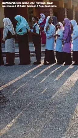  ??  ?? SEBAHAGIAN murid beratur untuk memasuki dewan peperiksaa­n di SK Sultan Sulaiman 2, Kuala Terengganu.