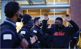  ??  ?? An activist holds his hands up outside Chicago police headquarte­rs during a rally on 15 April. Photograph: Kamil Krzaczyńsk­i/Getty Images