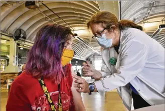  ?? NICK GRAHAM / STAFF ?? Lynn Hanck from Mercy Health gives a vaccine to Kayla Bittner. Mercy Health-Fairfield Hospital offered first-dose vaccinatio­ns at Jungle Jim’s Oscar Event Center in Fairfield on Tuesday.