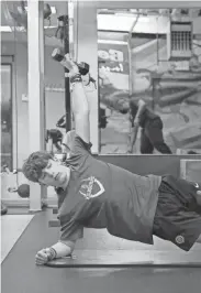  ?? ?? Miles Rush, 15, of Worthingto­n, exercises as trainer Justin Cunningham cleans equipment at 614Fitness on the North Side. Staff at 614Fitness wear masks while those working out have the option of wearing masks.