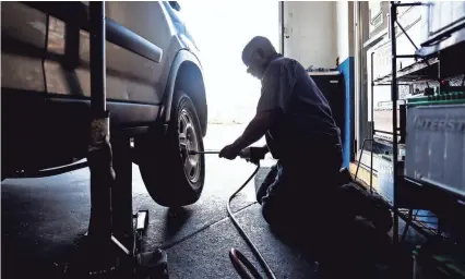  ??  ?? Long-time Holt Tire Pros serviceman William Hunt works on replacing a customer’s flat tire at the shop now shared with Oak Court Auto in East Memphis. MARK WEBER / THE COMMERCIAL APPEAL