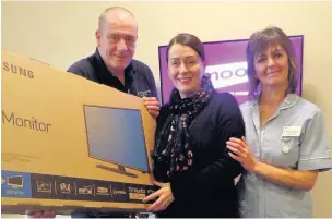  ??  ?? ●Lisa Greenhalgh has donated 11 TVs to Springhill Hospice in memory of her sister Linda, who died there She is pictured with Springhill head steward Mick Downes and nurse Hilda Wild