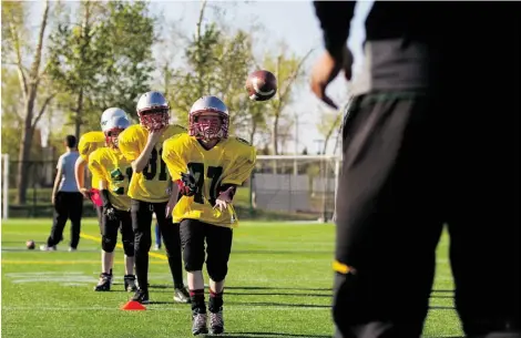  ?? TOPHER SEGUIN/EDMONTON JOURNAL ?? Participan­ts in the Edmonton Eskimos’ amateur football camp work on their receiving skills at Clarke Field earlier this week.