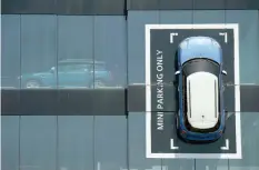  ??  ?? A Mini car is fixed onto a wall at a BMW dealership in Barcelona. — Reuters