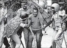  ?? ARUN SANKAR/GETTY-AFP ?? Police beat a demonstrat­or Wednesday during a protest against a court ruling that revoked a ban on most females entering a Hindu temple in southern India.