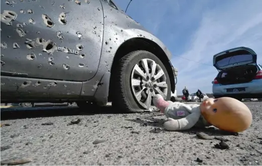  ?? SERGEI SUPINSKY/AFP VIA GETTY IMAGES ?? An abandoned doll lies next to a car riddled with bullets on Saturday in Irpin, north of the Ukrainian capital Kyiv.